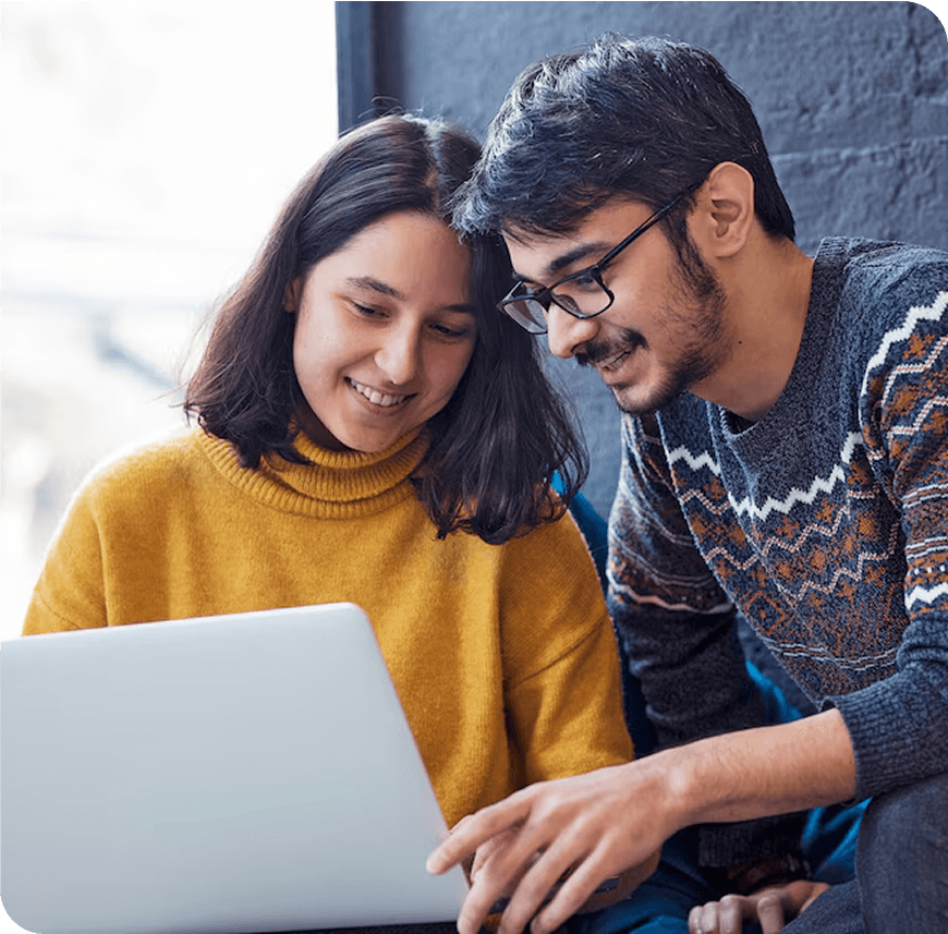 Two service providers discussing while using laptop.